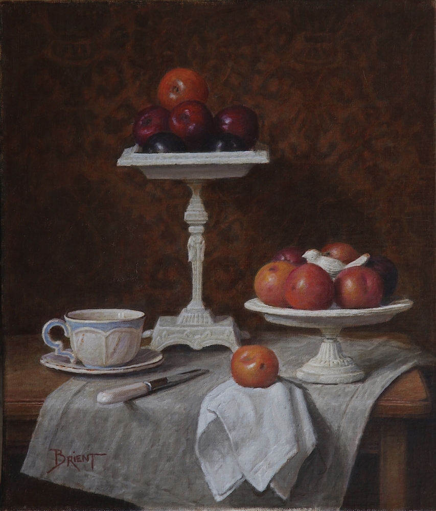 Deux plateaux de prunes, une tasse de couleur créme, un napperon de lin sur une table 12X14 