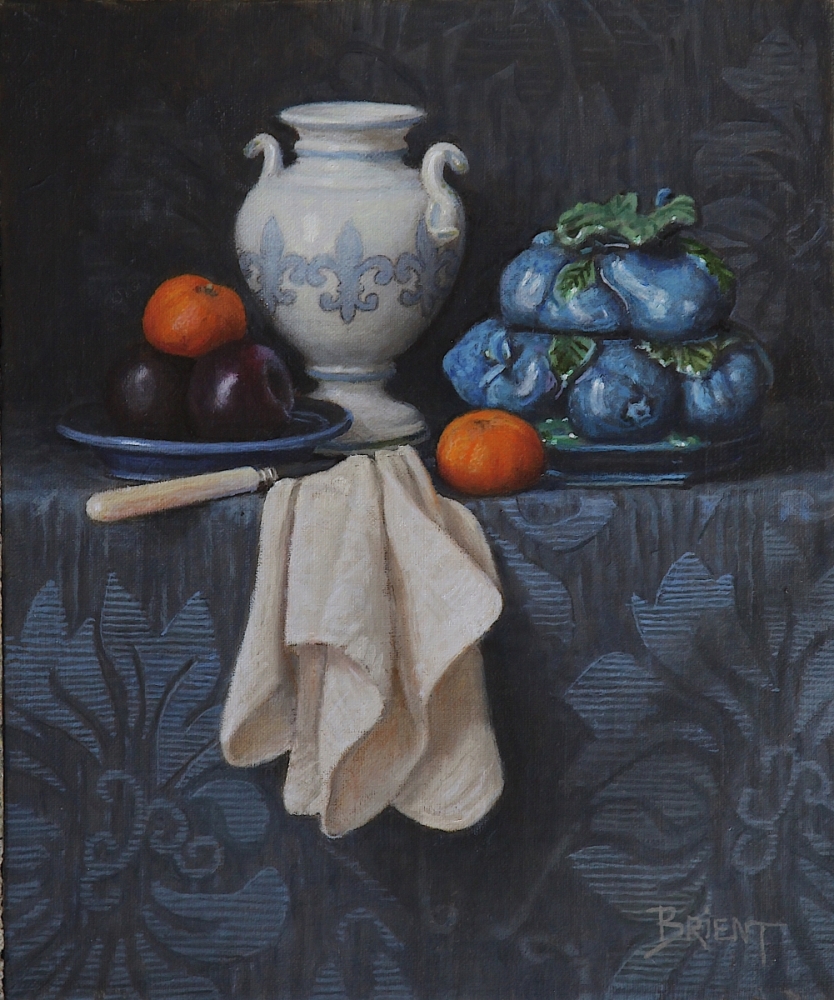 A white vase, a blue ceramic bowl, a plate of plums, two clementines